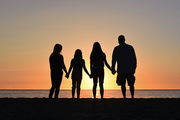 Group holding hands at sunset